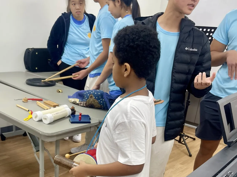 Volunteer helping a child with a music lesson